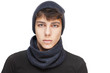 A handsome guy with a sad, angry face on a white background. He is wearing a warm cap and a scarf