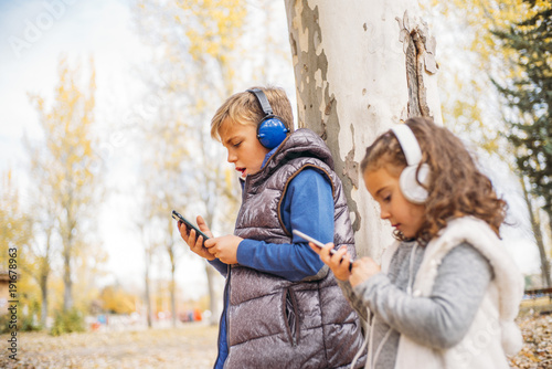 Fotografía Children listen to music in autumn landscape..