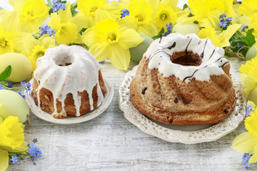 Wall Mural - Traditional easter cakes and bouquet of daffodils in the background.