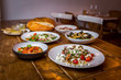 assorted salads in mediterranean restaurant  with focaccia bread in background on wooden table