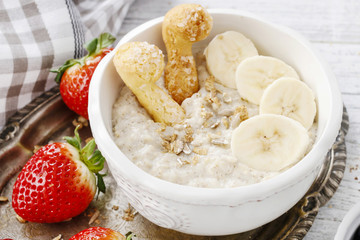 Wall Mural - Porridge with bananas and crunchy cookies.