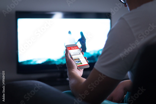 Man Reading Online News On Smartphone At Home Mobile Phone News
