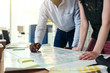 © Flamingo Images - Two designers working on building plans in an office