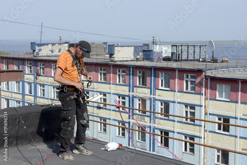 Fotografie, Obraz steeplejack testing his gear on the roof of the building