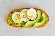 Sweet potato toast with avocado, eggs and chia seeds. Top view on a white marble background.