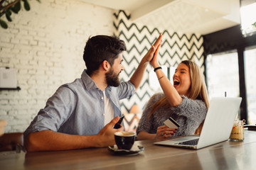 Front view of an excited couple buying online.