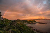 Fototapeta Tęcza - Rainbow and sunset along ocean coastline