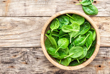 Fresh Baby Spinach Leaves In Bowl On Wooden Background
