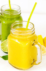 Poster - Banana Mango Smoothie and Green Spinach Avocado Smoothie  in mason jars. Healthy vegan eating.