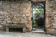 Iron gate in ancient stone wall with bench