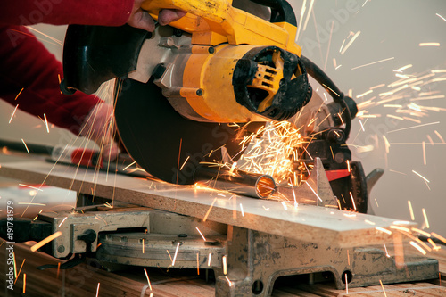 Fotografie, Obraz Cutting of a metal pipe with splashes of sparks