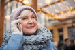 © Yakobchuk Olena - Portrait of happy senior woman talking on mobile phone and smiling. She is standing on street and smiling. Winter holidays concept