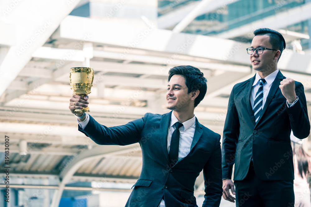 Happy Asian business people with golden trophy cup for their winner in ...