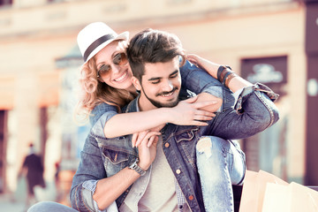 Wall Mural - Cheerful smiling couple in love hugging on the street.