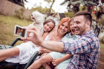 Happy family smiling at the camera with their dog