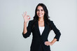© MARIIA - Everything is perfect. Beautiful young businesswoman looking at camera and gesturing OK with smile while standing against white background