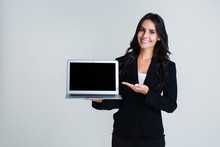 Have You Seen This Program? Beautiful Young Businesswoman Showing Her Laptop And Looking At Camera With Smile While Standing Against White Background