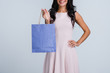© MARIIA - Your shopping bag. Part of beautiful young woman holding shopping bag with smile while standing against white background