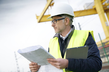 Wall Mural - Construction manager on site reading blueprint