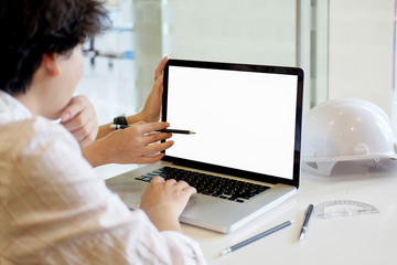 Shot of a two young designer at work with some blueprints and a laptop