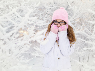 Wall Mural - Adorable happy young blonde woman in pink knitted hat scarf mittens having fun snowy winter park forest sunny day in nature