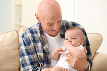 Poster - Senior man playing with his little grandchild at home