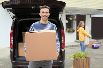 Poster - Young couple unloading their car on moving day