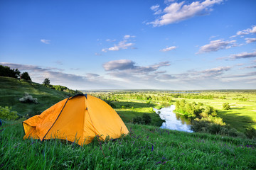 Wall Mural - orange tent on hill above the river