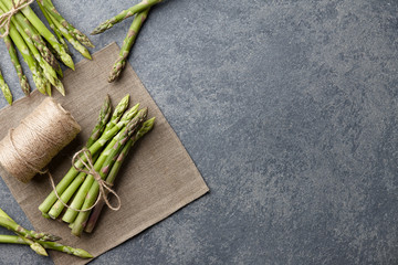 Wall Mural - Bunch of fresh green asparagus on dark wooden background, top view