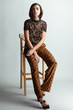 © Sergey Chumakov - vintage fashion woman sitting on wooden chair on white studio background