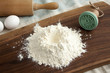 Kitchen utensils and ingredients for pastries on wooden board background, eggs, rolling pin, wooden board, cookie stamp