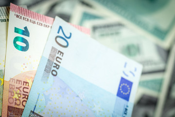 Wall Mural - Euro banknotes on dollar bills background close-up