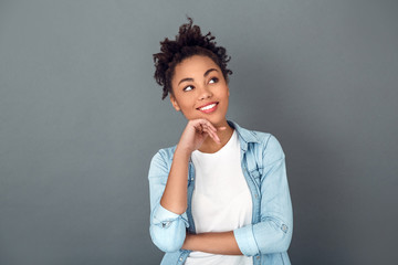 Young african woman isolated on grey wall studio casual daily lifestyle planning