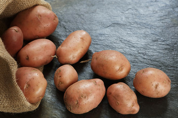 Wall Mural - Red Potatoes from burlap sack on slate table with copy space