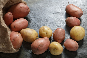 Wall Mural - Red Potatoes from burlap sack on slate table with copy space