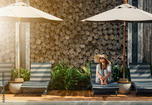 Women Wear Hat Sitting On Comfortable Chair In Pool Villa