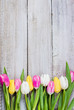 © Anikonaann - Fresh colorful tulips on a shabby wooden background for Mother's Day. Spring Easter Holiday Concept. Top view, copy space