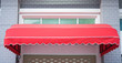 Red awning mounted on the front door of the shop.