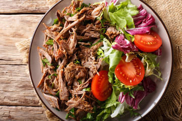 pulled spicy beef with fresh vegetables close-up on a table. horizontal top view from above