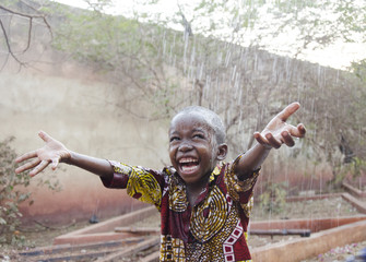 sweet little african boy under the rain in mali (africa)