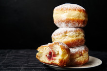 A Stack Of Three Sufganiyot Donuts With Jelly On Black Background