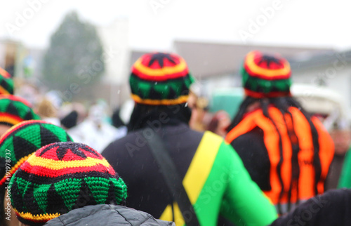 people with jamaica caps at carnival procession, rear view Poster Mural XXL