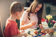 © Mediteraneo - Brother and sister painted Easter eggs at the table
