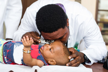 doctor consulting the baby's ears.