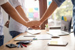 © khwanchai - Parthnership and teamwork concept, businessman take hand coordination over table or desk inclued paper graph and planning note  to get goals..