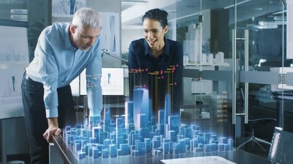 Male and Female Architects Work with Holographic Augmented Reality 3D City Model. Technologically Advanced Office Professional People Use Virtual Reality Modeling Software Application.