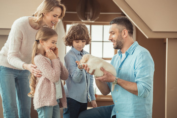 Wall Mural - young family with cute labrador puppy in front of cardboard house