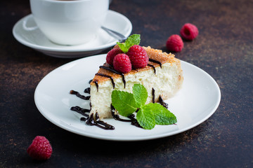 Wall Mural - Homemade cheesecake with fresh raspberries and mint decorated with chocolate on plate on dark table background . Healthy organic dessert. Vanilla Cheese Cake. Copy space