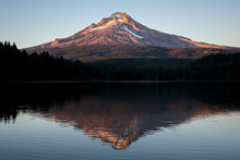 A View Of A Mountain Over A Lake At Sunset