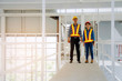 © Vittaya_25 - couple of engineers or technician man and woman with safety helmet holding blueprint in construction site building to greeting start up project, successful, business, industry, construction concept